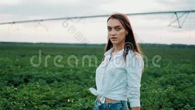 一个穿短裤的年轻农民女孩走过田野。 <strong>农产品</strong>种植.. 有机产品概念。 A.